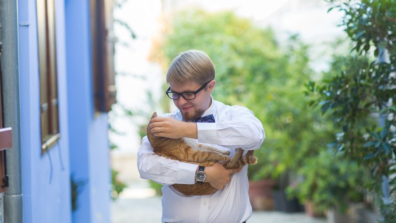 man and cat on street