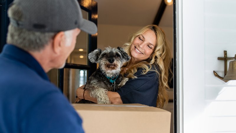 dog and delivery person hug