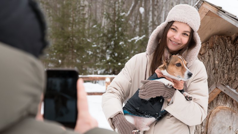 woman filming dog outdoors