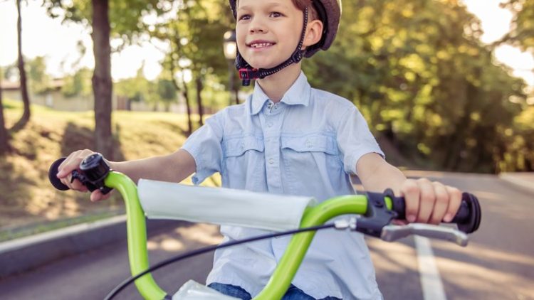 young boy cycling on road