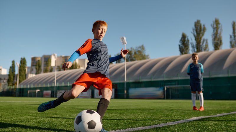 young soccer player dribbling ball
